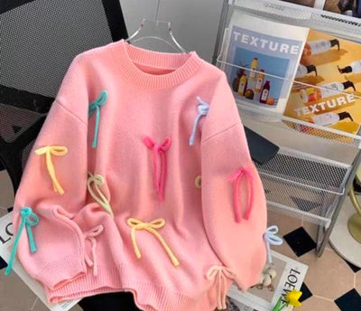 Many crossings pink sweater with bows.