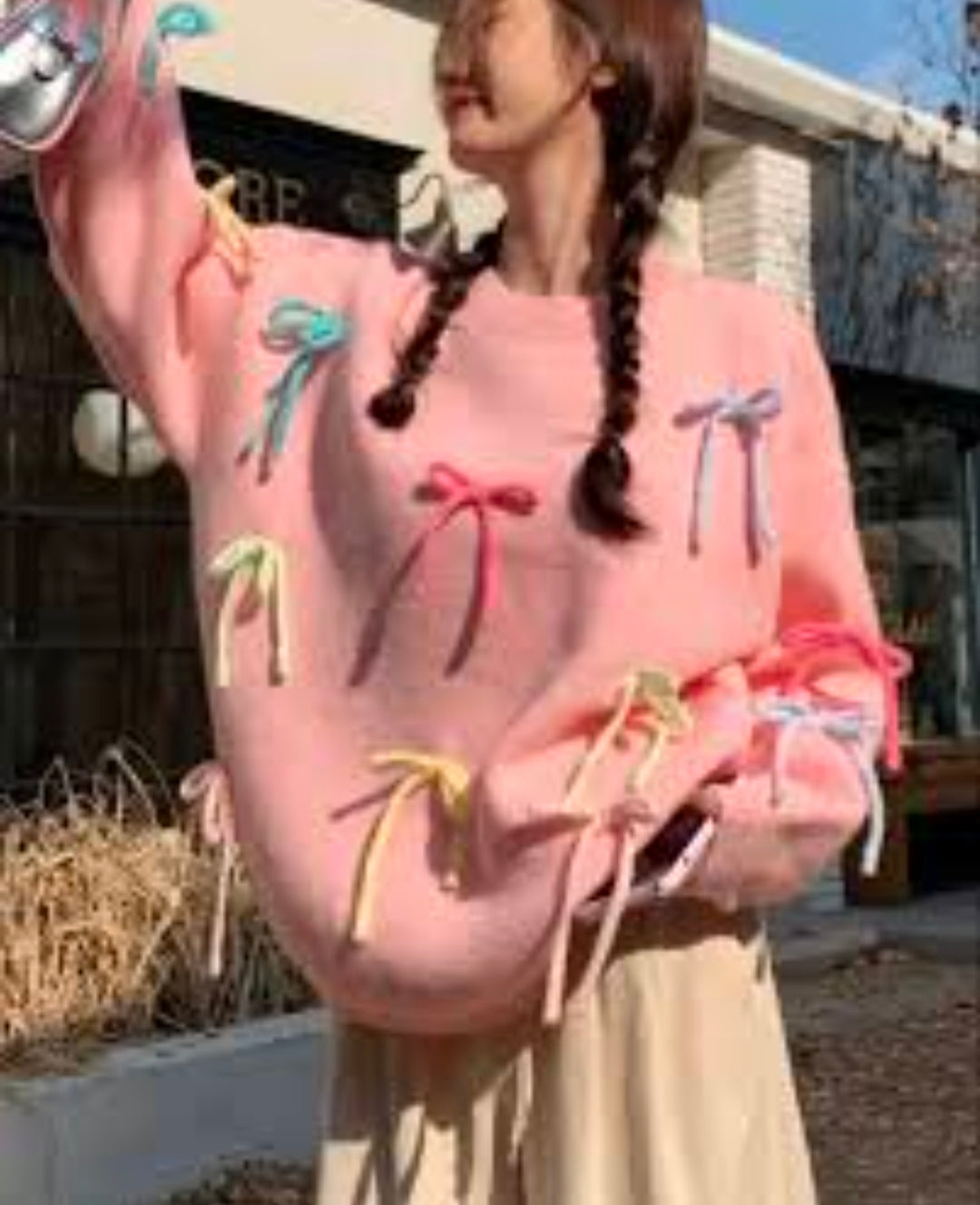Many crossings pink sweater with bows.